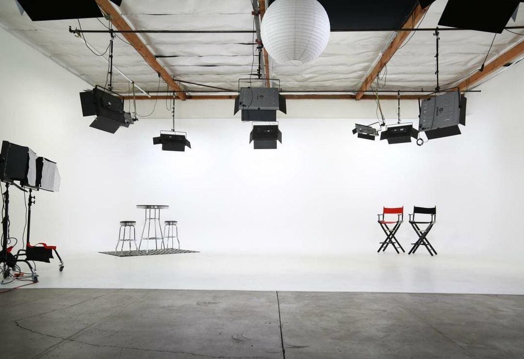 The Director's Cut — white cyclorama studio with director chairs